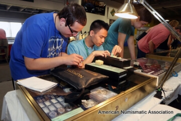 multiple people examining coins