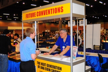 two people talking at a booth labelled future conventions