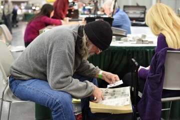 man examining coins at a show