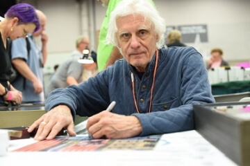 man sitting at a table at a show