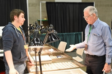 person at a coin show booth