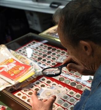 man examining a coin at a show