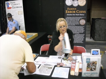 man bent over a coin show booth