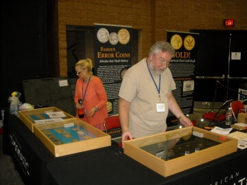 people looking at a.n.a. coin display