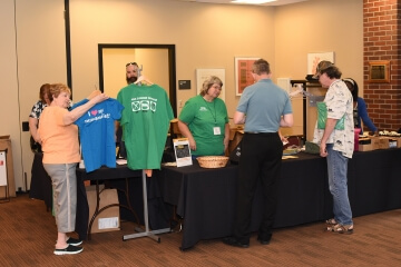 people with a rack of t-shirts for sale