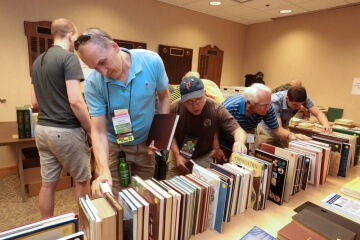 man looking at bookshelf