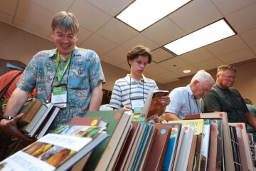 men in small library looking at books