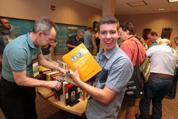 man holding up book