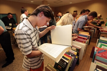 man looking at large book