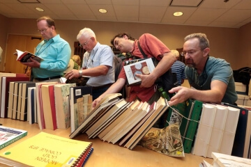 men in small library looking at books