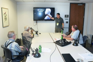 people sitting at a table watching a presentation