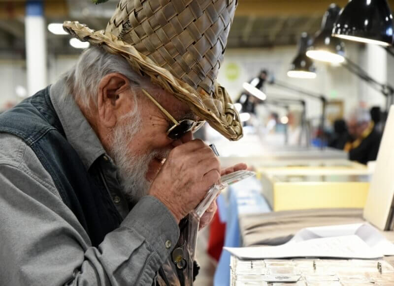 man studying coin with loupe