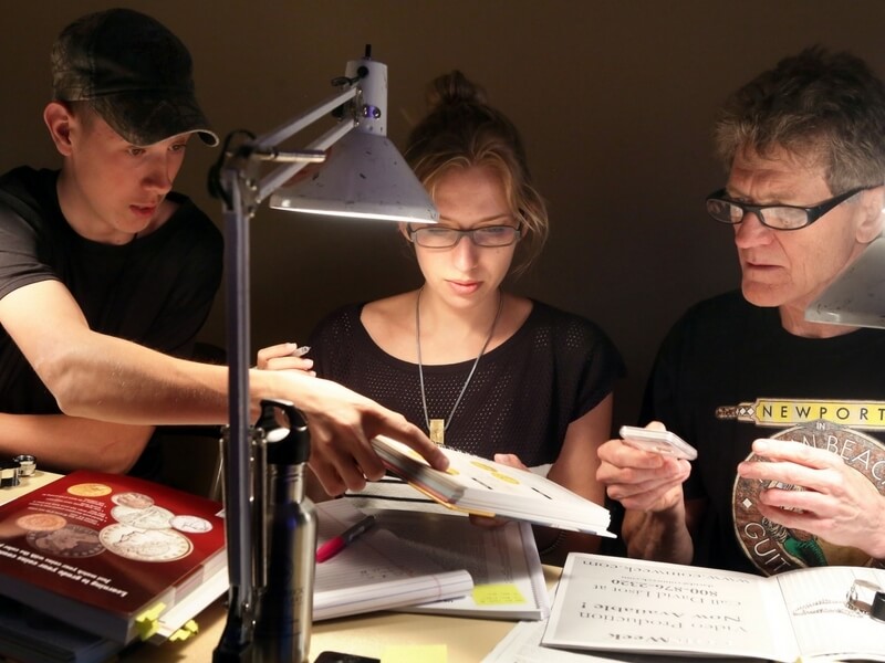 three people looking at a book