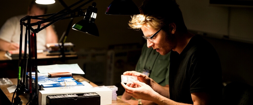 young man looking at coin