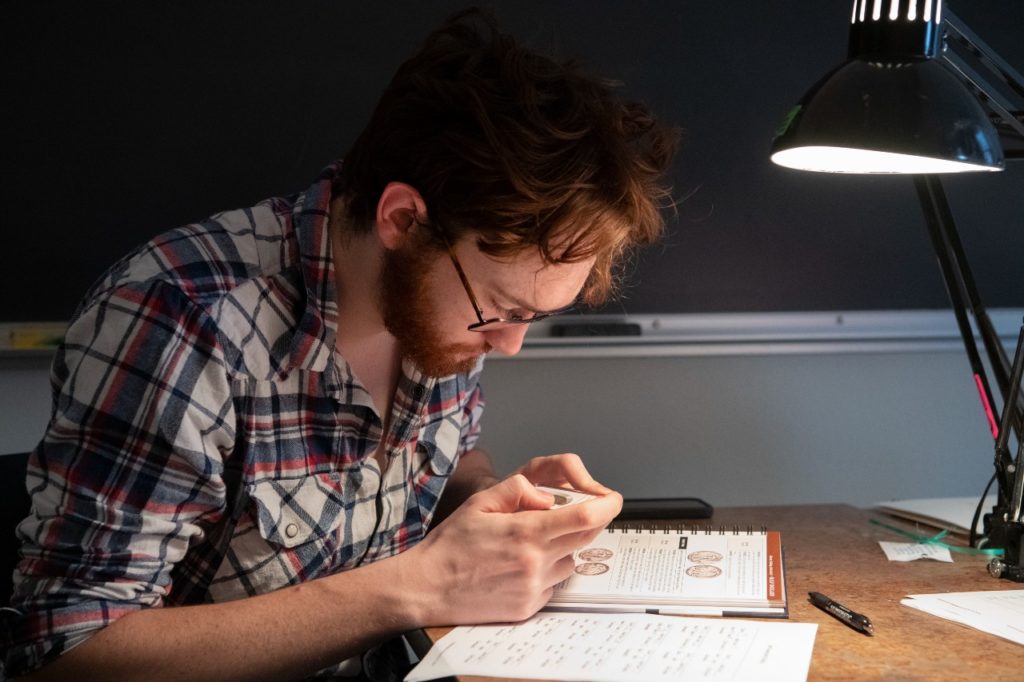 Young Man Examining Coins