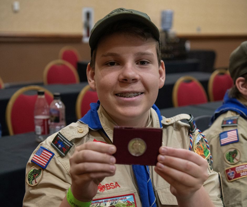 Scout holding coin