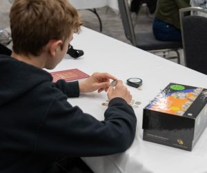 Examining a Coin at Young Collectors Corner