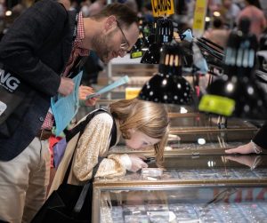 Father and Daughter Examining Coins on the Bourse